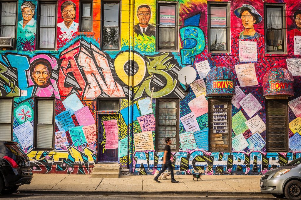 Pilsen neighborhood, Chicago IL, Man walking dogs near mural